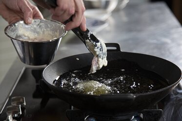 Put the veal strips into the hot oil 