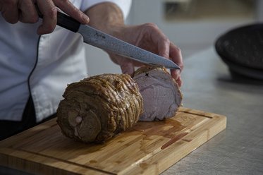 Carve the veal roulade into slices.